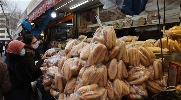 سيدتان أمام كشك لبيع الخبز في اسطنبول (أ ف ب)