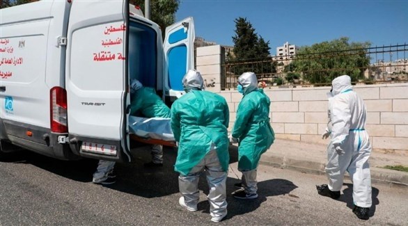 عاملون فلسطينيون ينقلون جثمان ضحية لكورونا (أرشيف)