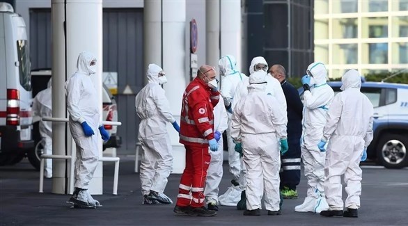 أطباء أمام مستشفى للتعامل مع مصابي كورونا في إيطاليا (رويترز)