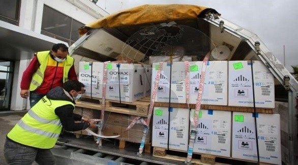 عاملان في مطار تونس قرطاج الدولي يستقبلان شحنة لقاحات فايزر (وكالة الأنباء التونسية)