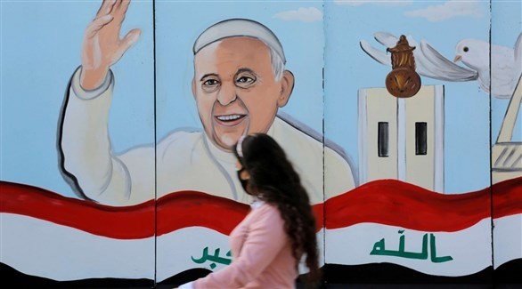 عراقية أمام ملصق عليه صورة بابا الفتايكان (أرشيف)