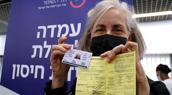 إسرائيلية تعرض شهادة تطعيمها باللقاح ضد كورونا (أ ف ب)