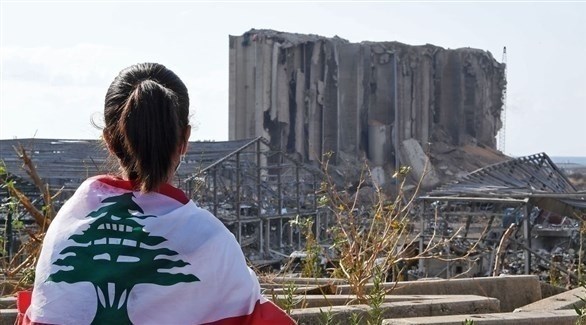 لبنانية أمام صوامع القمح في مرفأ بيروت المدمر (أرشيف)