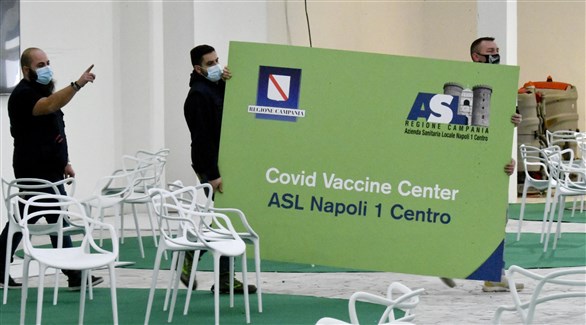 موظفون يجهزون مركزاً للتطعيم ضد كورونا في نابولي الإيطالية (أرشيف)