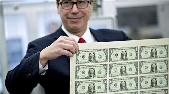 شخص يحمل ورقة تحمل الدولار الأمريكي (أرشيف)