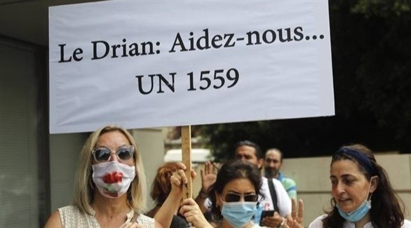 لبنانيات مناهضات لحزب الله يرفعن لافتة أمام سفارة فرنسا في بيروت "لودريان ساعدنا القرار الأممي 1559" (أرشيف)