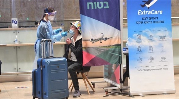 عاملة صحية تفحص مسافراً في مطار بن غوريون بإسرائيل (أرشيف)