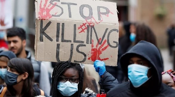 متظاهرة ترفع لافتة للمطالبة بوقف قتل السود في أمريكا (أرشيف)