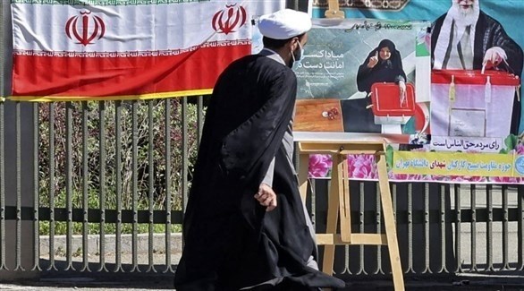 إيراني أمام ملصقات انتخابية في طهران (أرشيف)