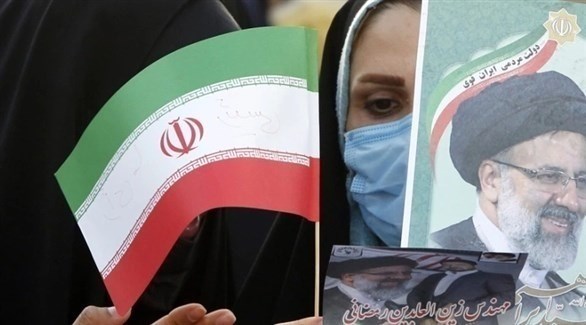 امرأة تحمل صورة رئيسي خلال تجمع انتخابي في طهران (اي بي ايه)
