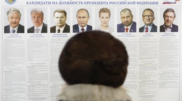ناخبة تعاين لائحة مرشحين للرئاسة الروسية (أرشيف / اي بي ايه)