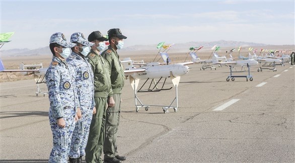 عسكريون إيرانيون يقفون قرب سرب من الطائرات المسيرة (أرشيف)