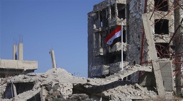 العلم السوري وسط أنقاض مبانٍ في درعا (أرشيف)
