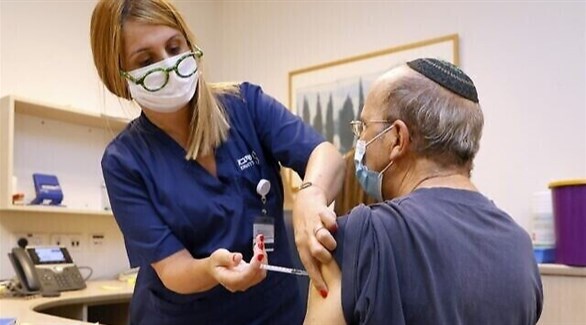 ممرضة إسرائيلية تطعم مسناً بلقاح ضد كورونا (أ ف ب)