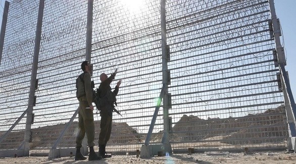 جنديان إسرائليان عند جزء من السياج الحدودي قرب غزة (أرشيف)