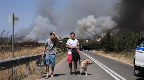 يونانيان يغادران أثينا هرباً من الحرائق (أ ف ب)