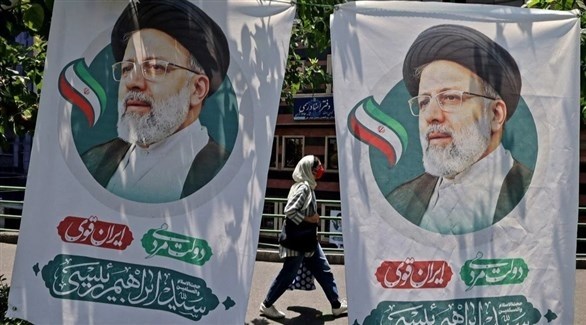 إيرانية أمام ملصقين لإبراهيم رئيسي (أرشيف)