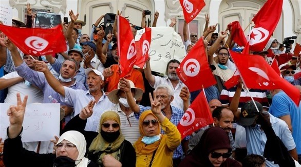 تونسيون يرفعون علم بلادهم وسط تونس (رويترز)