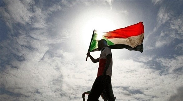 شخص يرفع العلم السوداني (أرشيف)