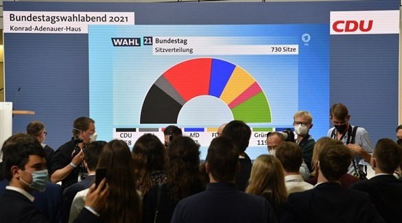 ألمان ينظرون إلى شاشة تعرض عليها نتائج الانتخابات التشريعية (أ ف ب)