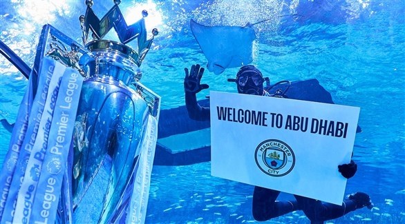أحد جماهير السيتي يحتفل بكأس الدوري الإنجليزي تحت الماء (وام)