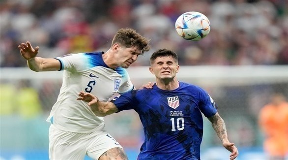 لاعبان إنجليزي وأمريكي يتصارعان على الكرة أمس في ملعب البيت في قطر (تويتر)