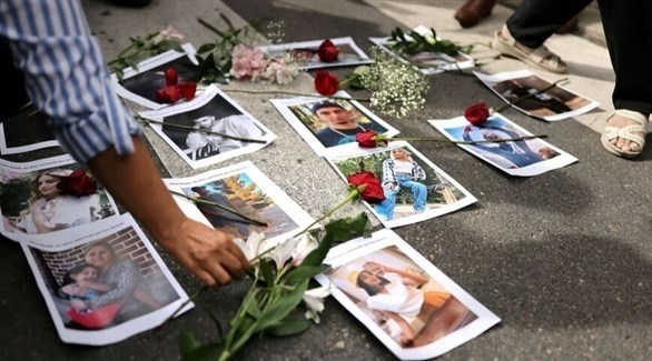 إيراني يضع وردة على صور بعض ضحايا القمع في البلاد (أرشيف)