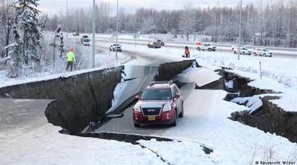 سيارة تعبر شارعاً متصدعاً إثر زلزال سابق في ألاسكا (أرشيف)
