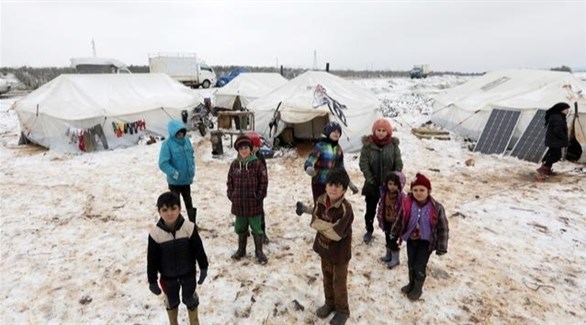 أطفال سوريون وسط الثلوج في مخيم نازحين (أرشيف)