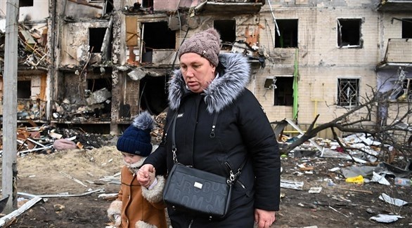 سيدة تمسك طفلة من يدها وسط الأنقاض في أوكرانيا (أرشيف)