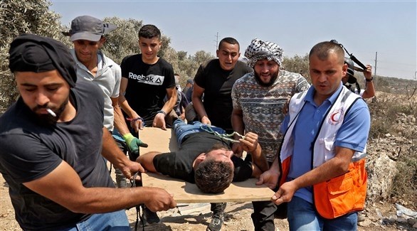 مسعفون ينقلون فلسطيني مصاب خلال اشتباكات (أرشيف) 