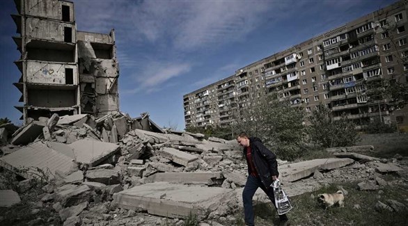 أوكراني يسير بمحاذاة مبنى مدمر (أرشيف)