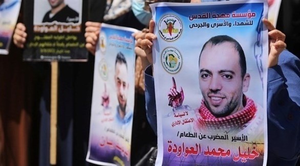 فلسطينيون يرفعون صورة الأسير خليل عواودة خلال فعالية مطالبة بالإفراج عنه (أرشيف)