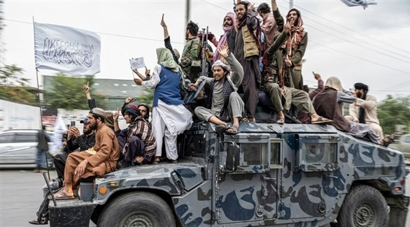 مقاتلون من طالبان يمرون بآلية هامفي أمام السفارة الأمريكية في كابول.(أف ب)