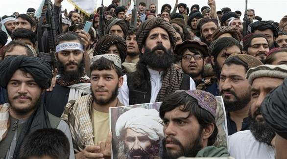 مقاتلون من طالبان يحملون صورة القيادي الأفغاني الراحل جلال الدين حقاني في كابول.(أف ب)