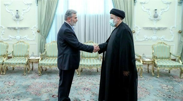الرئيس الإيراني إبراهيم رئيسي مستقبلاً زعيم "الجهاد الإسلامي" زياد النخالة في طهران.(أف ب)