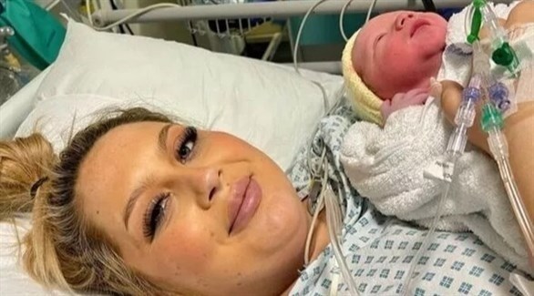 مولي جيلبرت على سرير المستشفى مع طفلها بعد الولادة (إكسبريس)