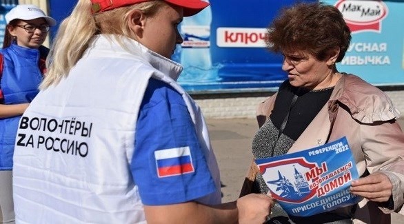 متطوعة في تنظيم الاستفتاء في زبروجيا الأوكرانية توزع منشوراً للتصويت (تويتر)