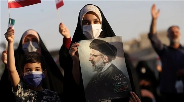 صبية تحمل صورة للرئيس الإيراني في طهران (أرشيف / رويترز)