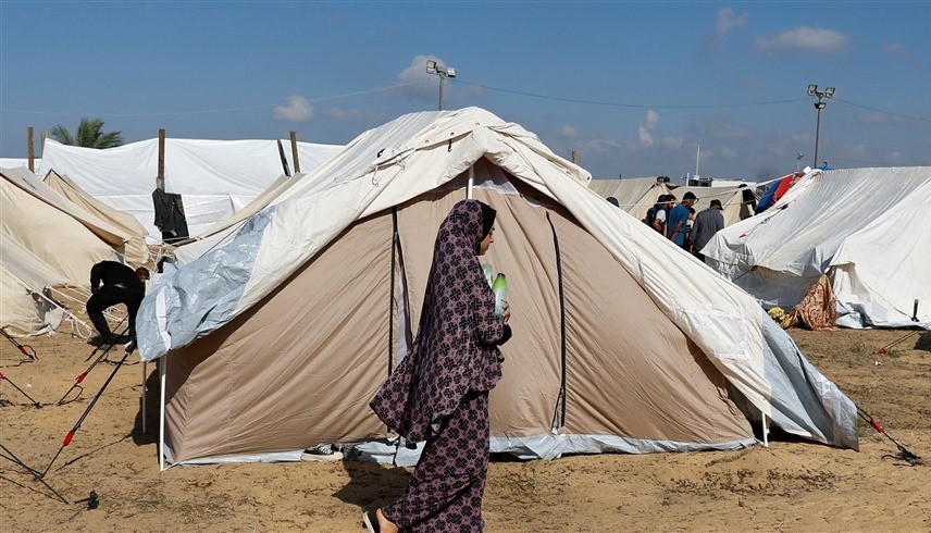 سيدة فلسطينية أمام خيمة في مخيم للنازحين بخانيونس جنوب قطاع غزة  (رويترز)