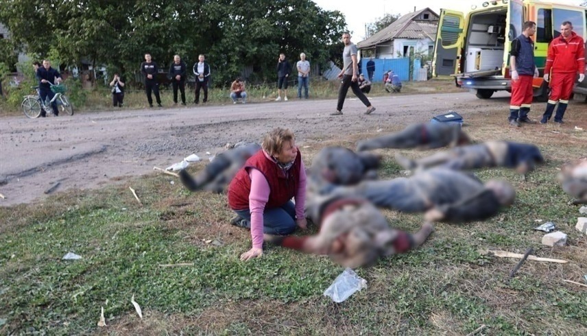 أوكرانية مكلومة بجانب جثث أشخاص قتلوا في قصف روسي بخاركيف (إكس)