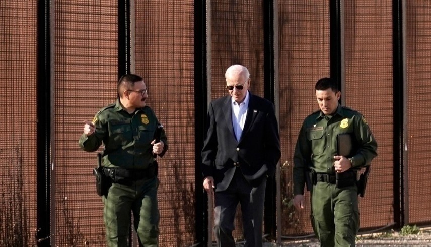 الرئيس الأمريكي جو بايدن بين عسكريين أثناء جولة عند الجدار الحدودي مع المكسيك (أرشيف)