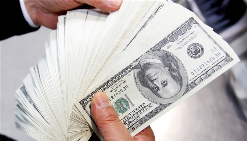 موظف في بنك  يعد أوراقاً نقدية من فئة مئة دولار أمريكي (رويترز)
