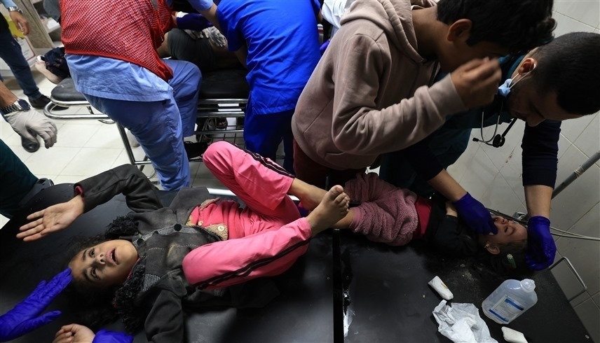 مسعفون يعالجون أطفالاً أصيبوا بغارة إسرائيلية على غزة (رويترز)