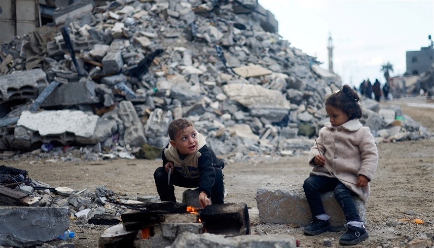 طفلان قرب منزل مدمر في خانيونس جنوب قطاع غزة (رويترز)