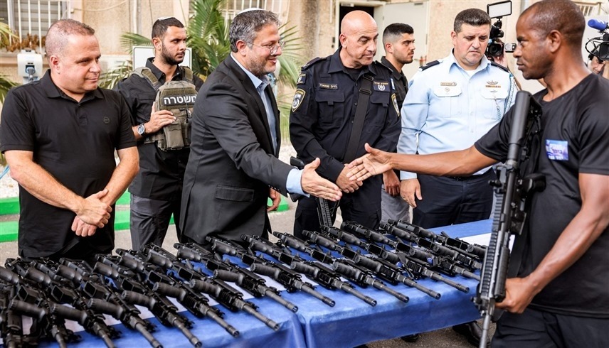 وزير الأمن القومي الإسرائيلي إيتمار بن غفير أثناء توزيع بنادق على مستوطنين (أ ف ب)