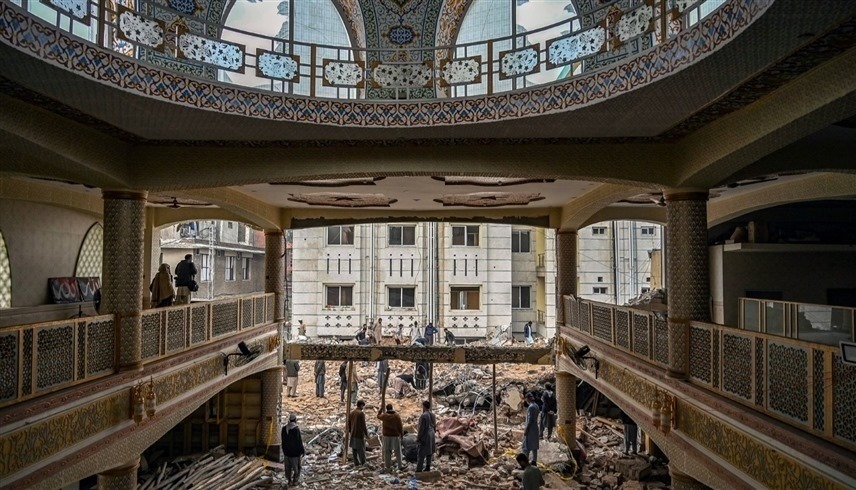 باكستانيون يتفقدون مسجداً في بيشاور دمر بتفجير إرهابي (أ ف ب)