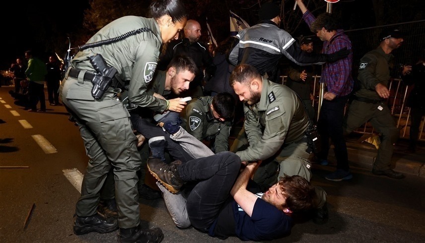 الشرطة الإسرائيلية تعتقل متظاهراً بعد إقالة وزير الدفاع (رويترز) 
