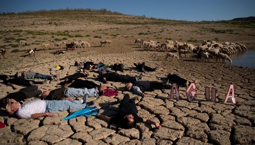 ناشطون بيئيون يستلقون في منطقة جافة في إسبانيا.(أف ب)