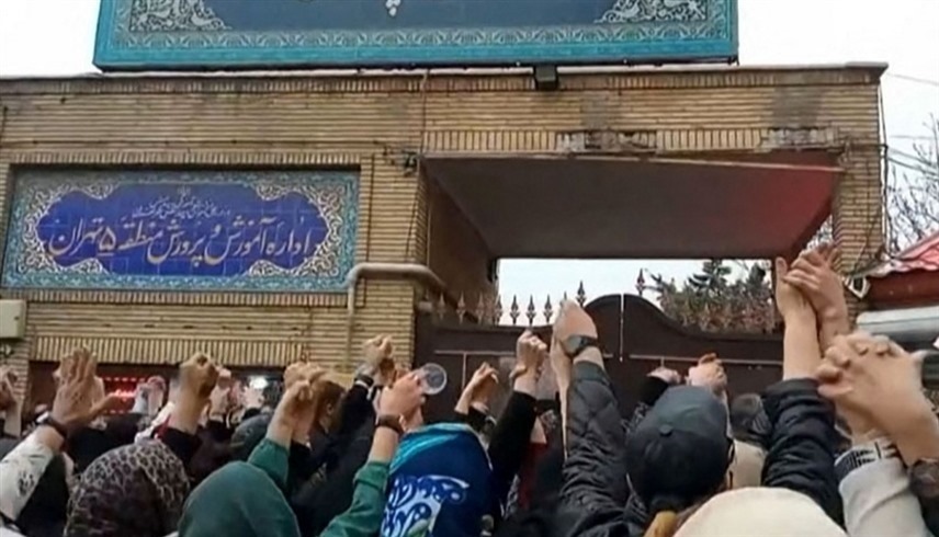 أهالي يطلقوان هتافات مناهضة للحكومة أمام مبنى وزارة التعليم في طهران.(أف ب)
